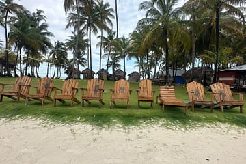 Sillas de playa vacías frente al mar en Isla Pelícano – Gorgi Nega, escenario de La Casa de Papel, San Blas, Panamá, esperando a recibir turistas.”