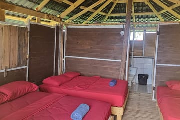 Cabaña privada de madera frente al mar en Isla Aguja, Guna Yala, rodeada de palmeras y arena blanca
